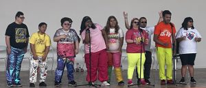 Group of young people with disabilities dancing on a stage.